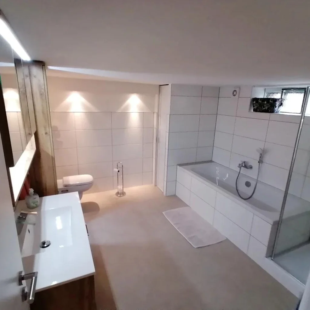 Neues Bad im Keller mit Badewanne, Waschtisch und warmem Licht