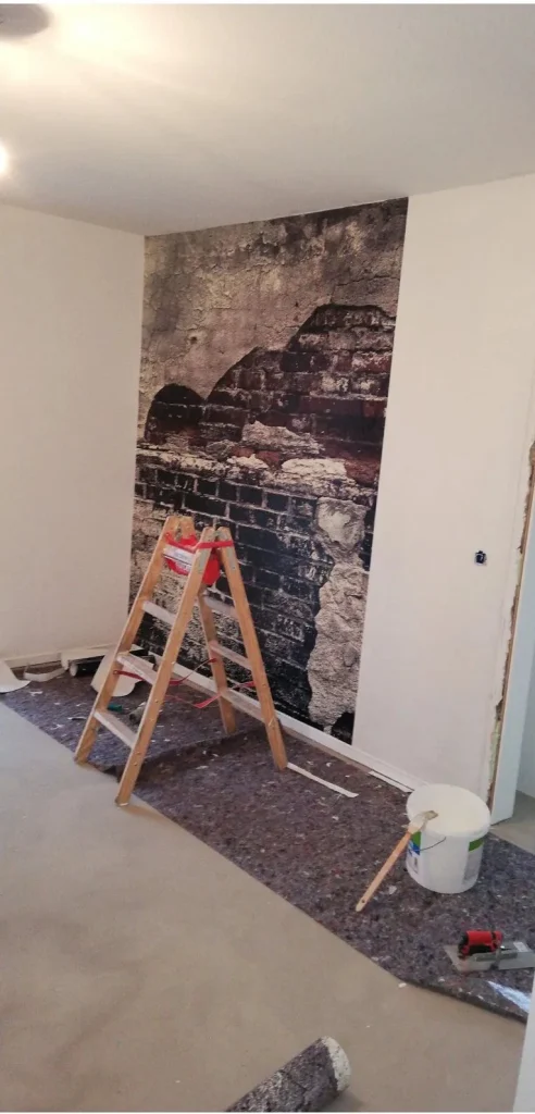Wand mit Fototapete in Backstein-Optik während der Arbeiten
